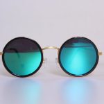 Elegant round sunglasses with blue-tinted lenses and gold frames, perfect for a trendy fashion statement.